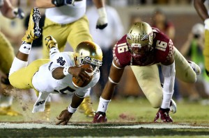 TALLAHASSEE, FL - OCTOBER 18:  Everett Golson #5 of the Notre Dame Fighting Irish dives with the ball as Jacob Pugh #16 of the Florida State Seminoles tries to make the stop during their game at Doak Campbell Stadium on October 18, 2014 in Tallahassee, Florida.  (Photo by Streeter Lecka/Getty Images)