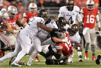 COLUMBUS, OH - NOVEMBER 21:  Ezekiel Elliott #15 of the Ohio State Buckeyes is gang tackled by Craig Evans #72 of the Michigan State Spartans, Riley Bullough #30 of the Michigan State Spartans and Lawrence Thomas #8 of the Michigan State Spartans in the third quarter at Ohio Stadium on November 21, 2015 in Columbus, Ohio. Michigan State defeated Ohio State 17-14.  (Photo by Jamie Sabau/Getty Images)